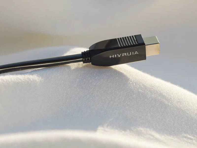 HDMI-Kabel mit geraden Steckern diagonal auf weißer Leinenfläche